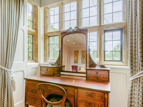 a bathroom with a wooden vanity and a mirror at Hodroyd Hall in Holmfirth