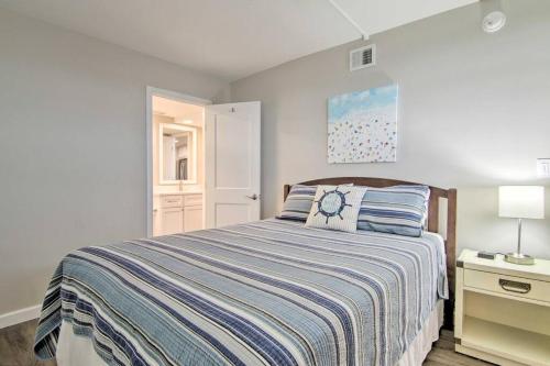 1 dormitorio con 1 cama con colcha de rayas azules y blancas en Fully Renovated Ocean Front Condo at Sea Colony, en Bethany Beach