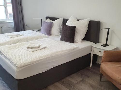 a bedroom with a large bed with white and purple pillows at QUELLQUARTIER in Fulda