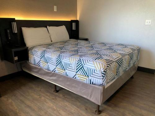 a bedroom with a bed with a blue and white comforter at Motel 6-Nogales, AZ - Mariposa Road in Nogales