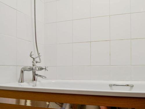 a bathroom sink with a white tiled wall at Stable Cottage - Ukc3630 in Adlestrop