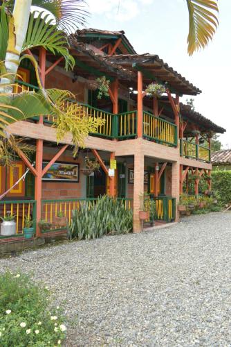 a wooden house with a balcony and a palm tree at Finca Hotel Villa Mariana in Montenegro