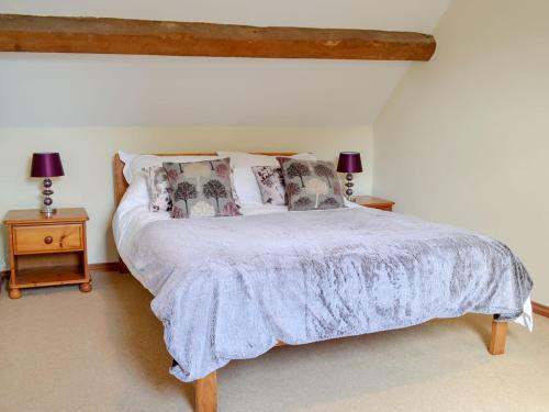 a bedroom with a bed and two lamps on tables at Stable Cottage - Ukc3630 in Adlestrop