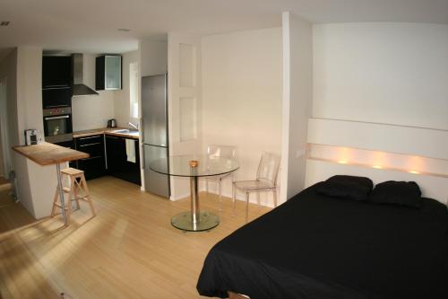 ein Schlafzimmer mit einem Bett und einem Tisch sowie eine Küche in der Unterkunft Appartement Le Sleidan in Straßburg