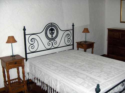 Casa da Janal في Vimioso: غرفة نوم بسرير كبير وطاولتين
