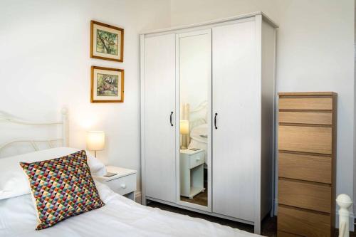 1 dormitorio con armario blanco y cama con almohada en Charming 1-bed Southside Flat in Great Location, en Kings Park