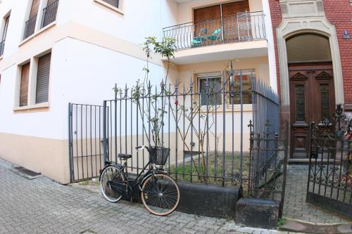 ein Fahrrad neben einem Zaun vor einem Haus geparkt in der Unterkunft Appartement Le Sleidan in Straßburg