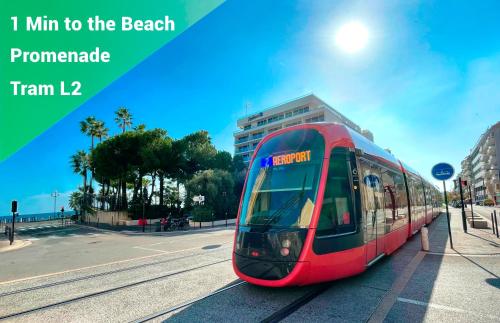 un train rouge sur les voies d'une ville dans l'établissement 1 Min to the Beach Apartment - Kitchen - Tramway - Air Conditioner - Wifi - Promenade Des Anglais, à Nice