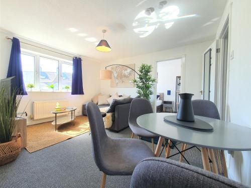 uma sala de estar com mesa e cadeiras em Thesiger Court Apartments - Free Private Parking - by Property Promise em Cardiff