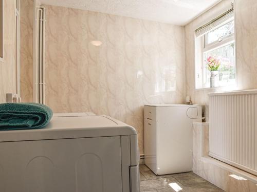 a bathroom with a washer and dryer and a window at Hengegin - Uk39874 in Llandybie