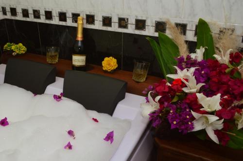a table with a bottle of wine and flowers on it at Hotel Antonio Nariño in Villa de Leyva