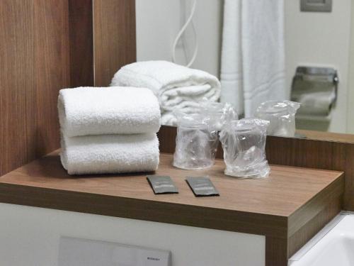 - une pile de serviettes sur un comptoir dans la salle de bains dans l'établissement Campanile Belfort Montbéliard - Gare La Jonxion., à Meroux