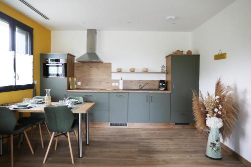 une cuisine avec une table et une salle à manger dans l'établissement Les Chalets du Bois Blanc, à Béville-le-Comte