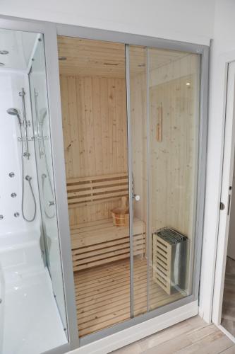 une douche avec une porte vitrée dans une salle de bain dans l'établissement Les Chalets du Bois Blanc, à Béville-le-Comte