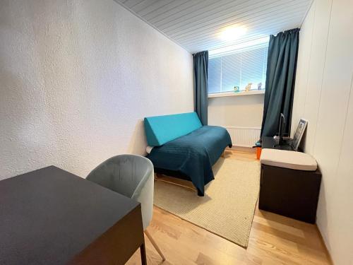 ein Wohnzimmer mit einem blauen Stuhl und einem Tisch in der Unterkunft Cosy and spacious apartment in Reykjavik in Reykjavík