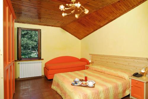 1 dormitorio con 1 cama y 1 silla roja en La Pinetina, en San Massimo