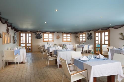 a dining room with white tables and chairs at Aladdin Beach Resort - Families and Couples Only in Hurghada