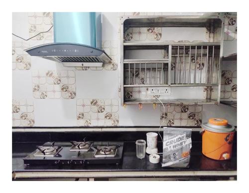 a kitchen with a stove and a stove top at Ujjayanta Homestay in Agartala