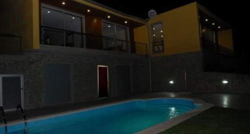 a swimming pool in front of a building at night at Casa campo ermal in Braga