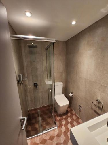 a bathroom with a toilet and a glass shower stall at Clayton Buenos Aires in Buenos Aires