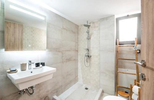 a white bathroom with a sink and a shower at Eleusis Suites Α in Eleusis