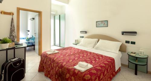 una stanza d'albergo con un letto con una coperta rossa di Hotel Stockholm a Rimini