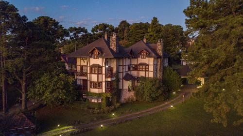 an aerial view of a large house with lights at Esquilo Hotel in Monte Verde