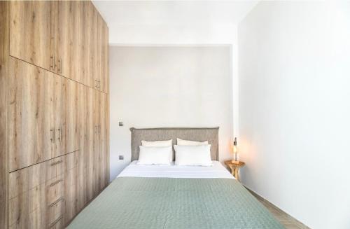 a bedroom with a large bed with a wooden headboard at Eleusis Suites Α in Elefsina