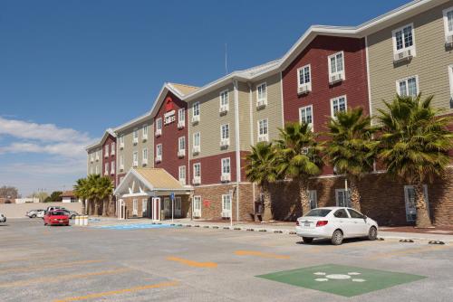 a parking lot in front of a large building at Extended Suites Queretaro Juriquilla in Querétaro