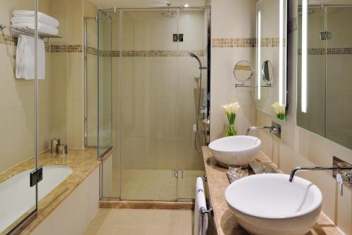 a bathroom with two sinks and a shower at Avani Deira Dubai Hotel in Dubai