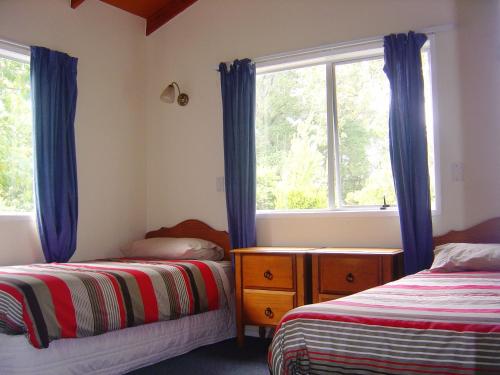 Ohuka Lodge في Tuai: غرفة نوم بسريرين ونافذة