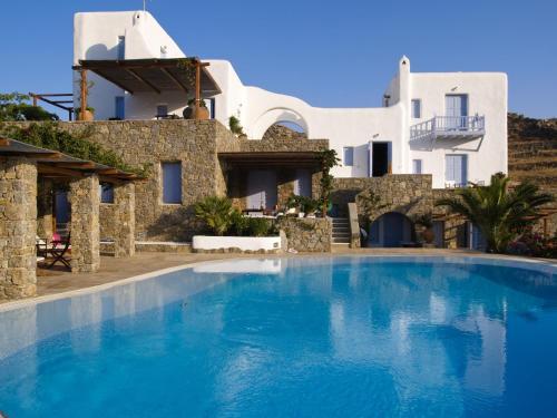 a large blue swimming pool in front of a house at Nama Villas in Super Paradise Beach