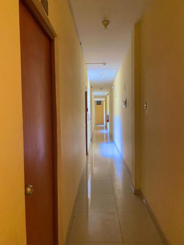 ein leerer Flur in einem Gebäude mit einem langen Korridor in der Unterkunft HOSTAL BULEVAR in Piura
