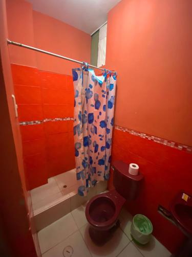 a red bathroom with a toilet and a shower at HOSTAL BULEVAR in Piura