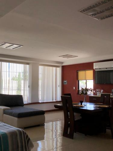 sala de estar con sofá y comedor en Departamentos Bonsai en Torreón