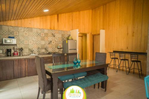 a kitchen with a glass table and chairs and a counter at Cabaña La Mazatleca en Mexiquillo in La Ciudad