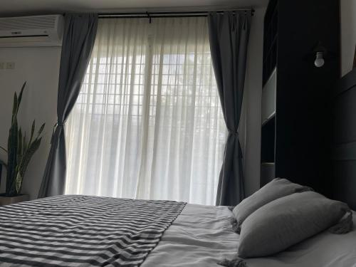 1 dormitorio con cama y ventana grande en Estudio en Belén de Escobar