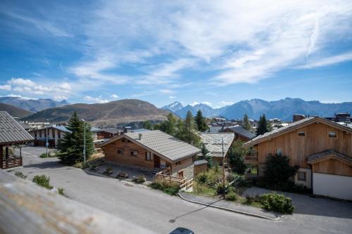 a view of a village with mountains in the background at Appartement du Poutat - Welkeys in LʼHuez