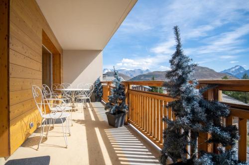 balkon ze stołem, krzesłami i choinką świąteczną w obiekcie Superb apartment with balcony in the heart of Huez - Welkeys w mieście LʼHuez