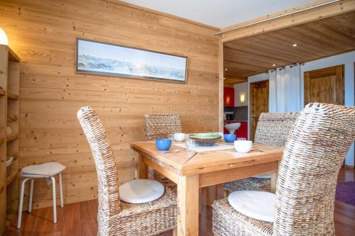 a wooden dining room with a wooden table and chairs at Appartement du Poutat - Welkeys in LʼHuez