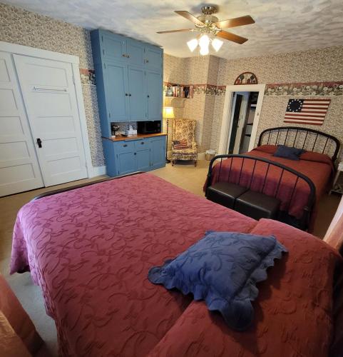 a bedroom with two beds and a ceiling fan at Prairie House Manor Bed and Breakfast in De Smet