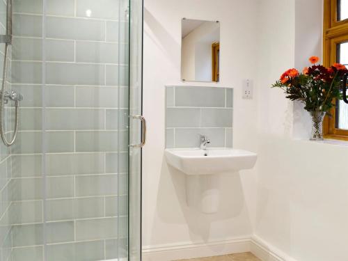 a white bathroom with a sink and a shower at Seventeen Ten in Castle Carrock