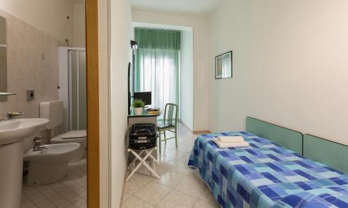 a bedroom with a bed and a bathroom with a sink at Hotel Stockholm in Rimini