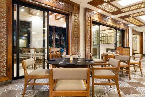 a restaurant with a table and chairs and windows at Villa La Valencia Beach Resort & Spa Los Cabos in San José del Cabo