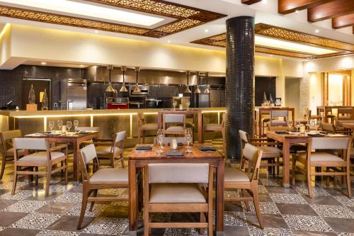 a restaurant with tables and chairs and a kitchen at Villa La Valencia Beach Resort & Spa Los Cabos in San José del Cabo