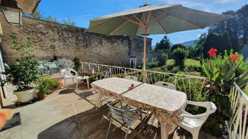 une table et des chaises avec un parasol sur une terrasse dans l'établissement CHEZ PIERRE, à Remoncourt