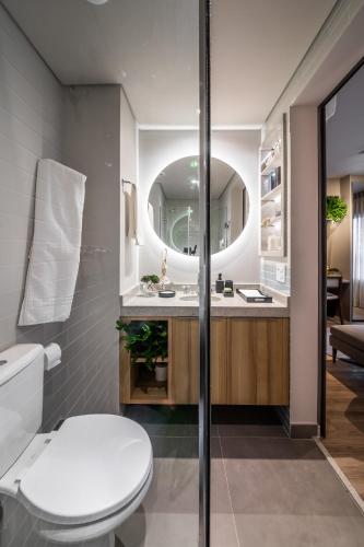 a bathroom with a toilet and a mirror at Noon Vila Madalena in Sao Paulo