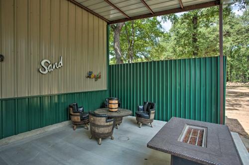 a patio with a table and chairs and a green wall at Kingston Home with Pickleball Steps to Lake Texoma! in Kingston
