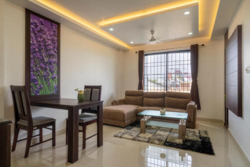 un soggiorno con divano e tavolo di Kay Pee's Grande a Cochin