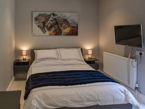 a bedroom with a bed and a flat screen tv at Hoggets Nest in Bedingfield